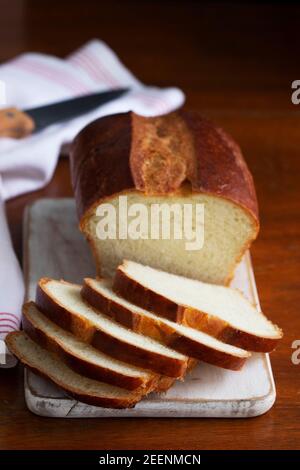 Sweet bread and slices of bread on a wooden table. Stock Photo