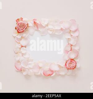 Creative composition made with rose flowers and petals  with paper card note. Minimal nature love background. Spring or summer flowers concept. Stock Photo