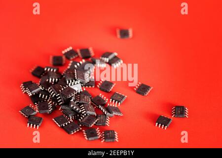 Pile of Integrated circuit chip red on background with copyspace. Microchip type soic8. Electronic components and spare part Stock Photo