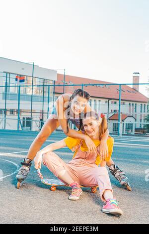 Young Two Sports Women Friends in Sports Clothes are Sitting on