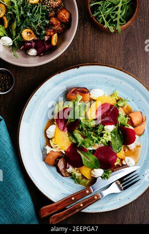 Top view of salad with salmon, radish, zucchini and beetroot on wooden table Stock Photo