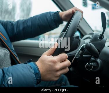 Man driving his car - hands on the steering wheel Stock Photo