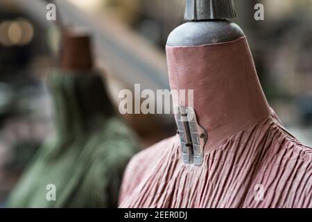 Close up of a pink and green faded tailor's dummies in an old and abandoned Italian textile factory Stock Photo