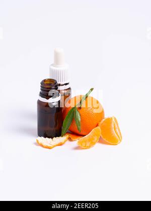 isolate, glass vial with pipette and tangerine on white background Stock Photo