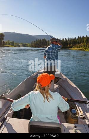 Tim Linehan fly fishing while Joanne Linehan guides the drift boat on the Kootenai River. Lincoln County, MT. (Photo by Randy Beacham) Stock Photo