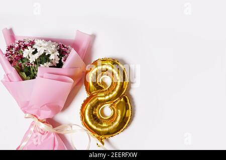 8 golden number ballon with bouquet of flowers. white background. Woman's holiday and 8 march concept. greeting card Stock Photo
