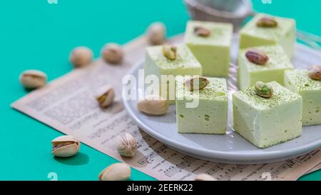 Handmade souffle candy with pistachioon on a bright background. Homemade sweets or candies. Pistachio souffle. Selective focus Stock Photo