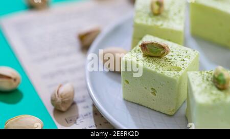 Handmade souffle candy with pistachioon on a bright background. Homemade sweets or candies. Pistachio souffle. Selective focus Stock Photo