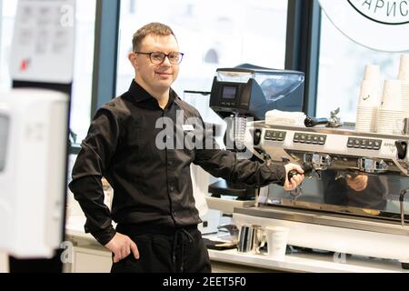 MINSK, BELARUS - January 2021: Disability Inclusion Team at an inclusive cafe. A unique project, an inclusive coffee shop. A place where all employees are disabled. Managed by a person with Down syndrome. All baristas are disabled. This is Mher Minosyan. He is 29 years old. Down syndrome. Works as a barista in an inclusive coffee shop. Leads a healthy lifestyle and enjoys sports. Stock Photo
