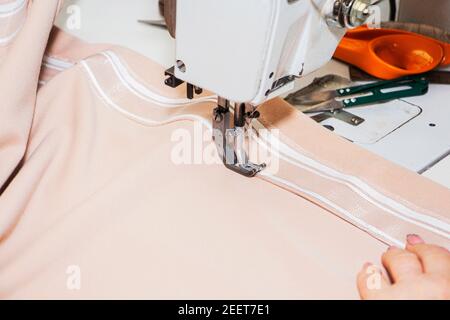 A seamstress, sewing a dress on a sewing machine. Close-up. Stock Photo