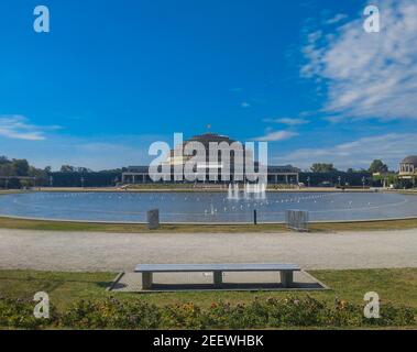Panorama of Pergola fountain in Wroclaw and stairs path with centennial hall in background and bench in front of Stock Photo