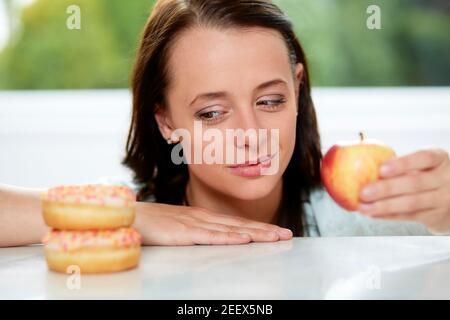 Girl making choice between healthy/unhealthy food Stock Photo