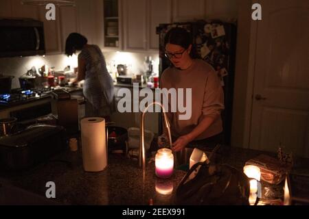 Argyle, Texas, USA. 15th Feb, 2021. After a snowstorm hits the state of Texas, many Texans are left without power. The state of Texas has chosen to use the rolling blackout to save energy in the state. 2/15/21, Argyle, Texas. In Argyle, Texas, families use canal light at night and try their best to cope with the situation. The Olson family, who has tested positive for COVID-19 seven days ago, has been experiencing blackouts the whole day. I the morning, this family and their neighbors have lost water pressure due to a tripped pump in the city. (Credit Image: © Chris Rusanowsky/ZUM