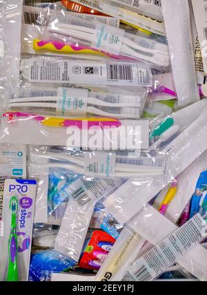 A crate of toothbrushes in plastic packaging donated to a Trussell Trust foodbank for orral hygiene. A range of manual toothbrush types and brands. Stock Photo