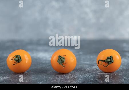 Three separated yellow cherry tomatoes on board Stock Photo