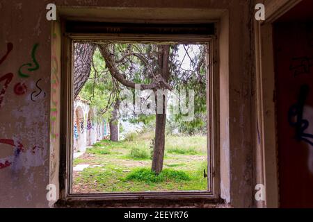 Villa Levidi, Pallini, Greece - February 14, 2021: Window view of an abandoned old villa at Pallini, Greece Stock Photo
