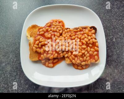 Baked beans on toast on a white plate