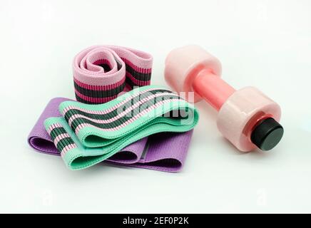 Sport Equipment. Exercises at Home Colorful resistance bands , pink Dumbbells isolated on white 