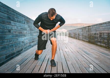Man runner having stomach side cramps or stitch during training. Athlete suffering from pain in his side. Side pain after jogging or running. Stock Photo