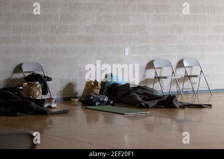 Austin, Texas Feb. 16, 2021: A homeless man fleeing the extreme cold of the Texas snowstorm sleeps at a church-run emergency shelter downtown. A historic snow of 6 inches coupled with bitterly cold temperatures have forced hundreds living outside to seek shelter. Credit: Bob Daemmrich/Alamy Live News Stock Photo