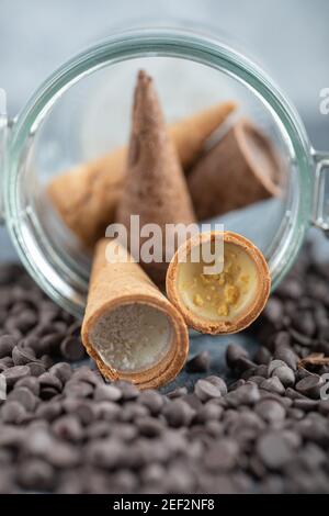 Sweet Conus candy with chocolate in glass. Brown background Stock Photo