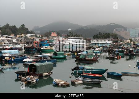 Yau Tong, Hong Kong - March 15 2019: Boats in the Sam Ka Tsuen typhoon shelter harbor face the Lei Yue Mun fishing village famous for its seafood rest Stock Photo