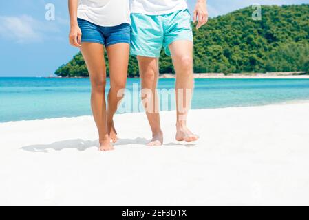 Couple walking on the beach in summer - lower bodies Stock Photo