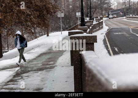 Student walks around Ohio University during a snowstorm Uri.Snowstorm Uri swept across the United States from February 12th to the 16th covering the United States in snow and Ice. Uri begun in the Pacific Northwest, and headed all the way to the southeast of US. The storm has claimed many lives due to car accidents and low temperatures. In Athens County Ohio the storm began on Monday morning February 15, 2021 and has continued into Tuesday 16, 2021. Currently Athens County is under a level two snow emergency. Stock Photo