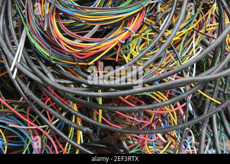 Multicolored wires and cables coiled in a heap behind a local electrician's shop Stock Photo