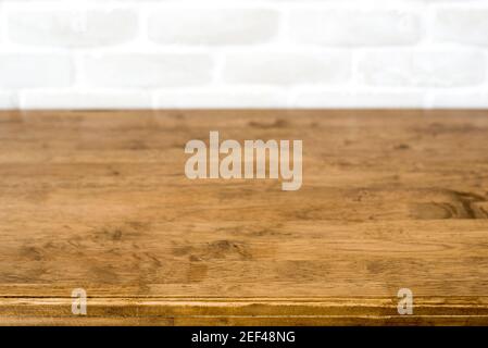 Wood table top on blurred white brick wall background - can be used for display your products (or food) Stock Photo