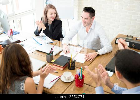Business people giving their colleague the applause at the meeting in creative office Stock Photo