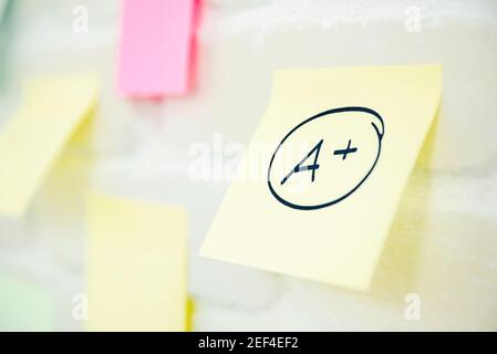 A plus grade written on notepad paper at the wall Stock Photo