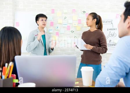 Group of students presenting and discussing project in classroom Stock Photo