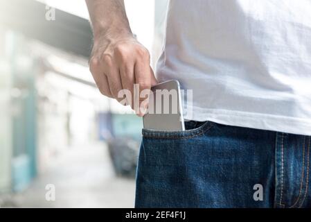 A man picking up smartphone from jeans pocket Stock Photo
