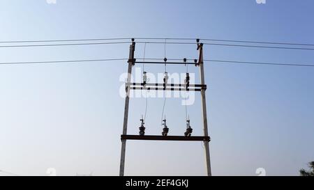 10 February 2021- Sikar, Jaipur, India. Domestic electricity transmission lines on white cement poles. High voltage transfer lines with electrical ins Stock Photo