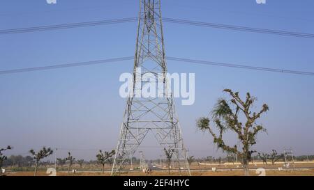 10 February 2021- Sikar, Jaipur, India. Triangular shape iron power supply posts with blue sky nature background. Electricity transmission tower and s Stock Photo