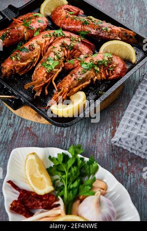 Grilled large queen shrimps with lemon and spices on grill pan Stock Photo