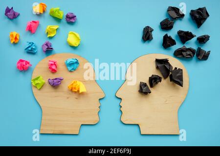 Negative and positive thinking concept. Head shapes with color paper balls. Stock Photo