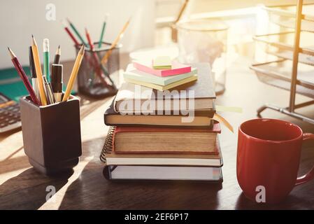 Stack of books and stationery on the desk - vintage tone effect Stock Photo