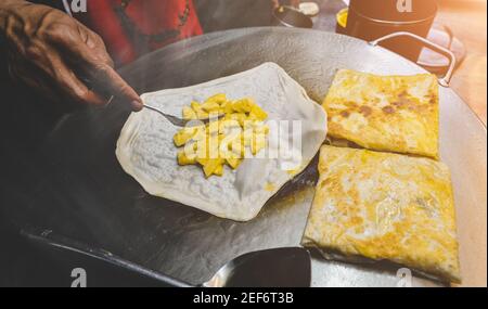 Indian street food roti sweet snack on the iron plate with night lighting. Stock Photo