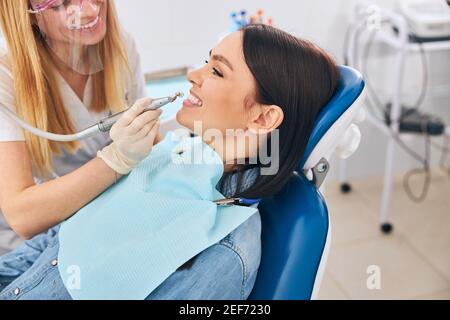 Positive delighted young woman sitting in dentistry chair Stock Photo