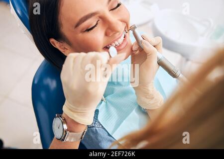 Focused photo on female hand that using drill machine Stock Photo