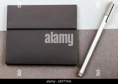Grey pen and black letter envelope on the black and gray papers background and texture, gray gradient Stock Photo