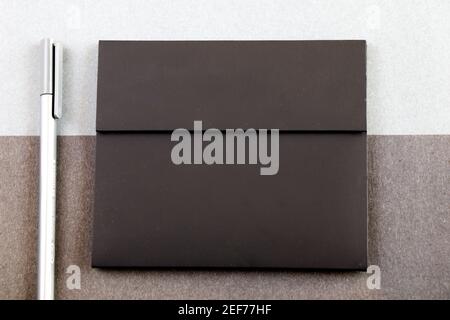 Grey pen and black letter envelope on the black and gray papers background and texture, gray gradient Stock Photo