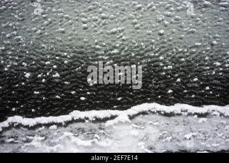 The frozen rear windshield of a car on the streets after snow and freezing rain. Stock Photo