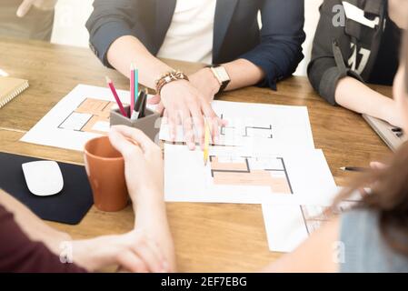 Group of architects (or interior designers) discussing floor plans in the meeting Stock Photo