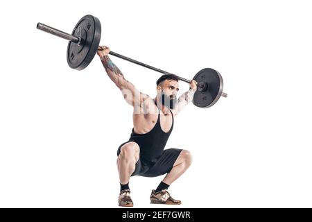 The technique of doing an exercise of deadlift with a barbell of a muscular strong tattooed bearded sports men on a white studio background. Isolate. Stock Photo