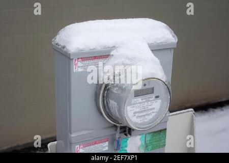 A frozen electricity meter is seen outside a residential building in Lake Oswego, Oregon, after snow and freezing rain hits Portland metro area. Stock Photo