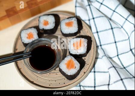 Japanese sushi rolls served on plate on gray background Stock Photo