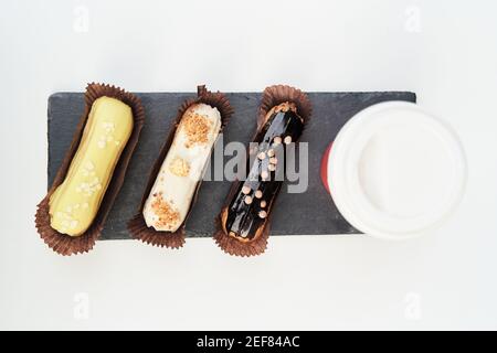 Three eclairs on a black tray top view Stock Photo